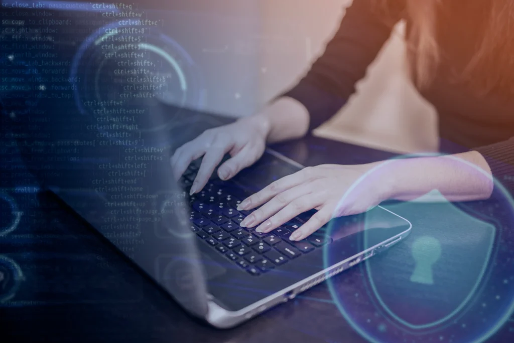 Mujer trabajando en laptop con elementos de ciberseguridad.