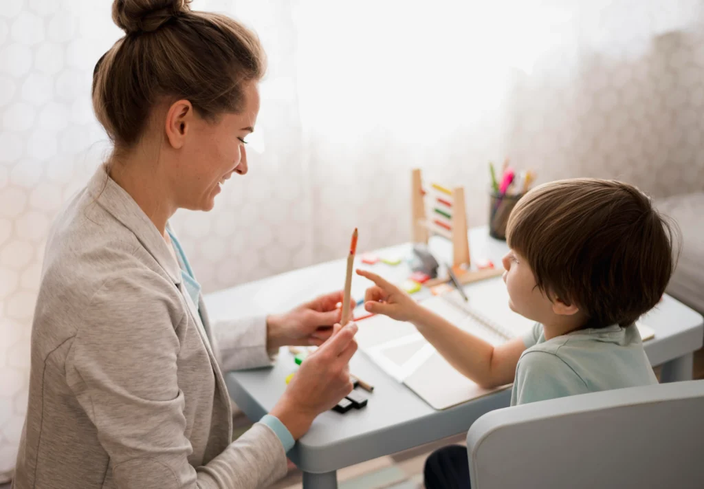 Mujer y niño pintando con lápices de colores.