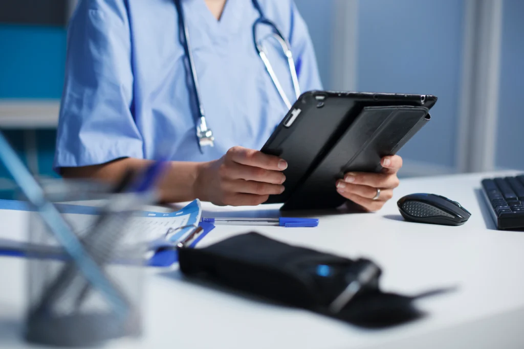 Médico usando tableta en consulta médica.