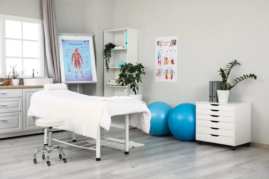 Sala de terapia física con camilla y equipo de ejercicio.