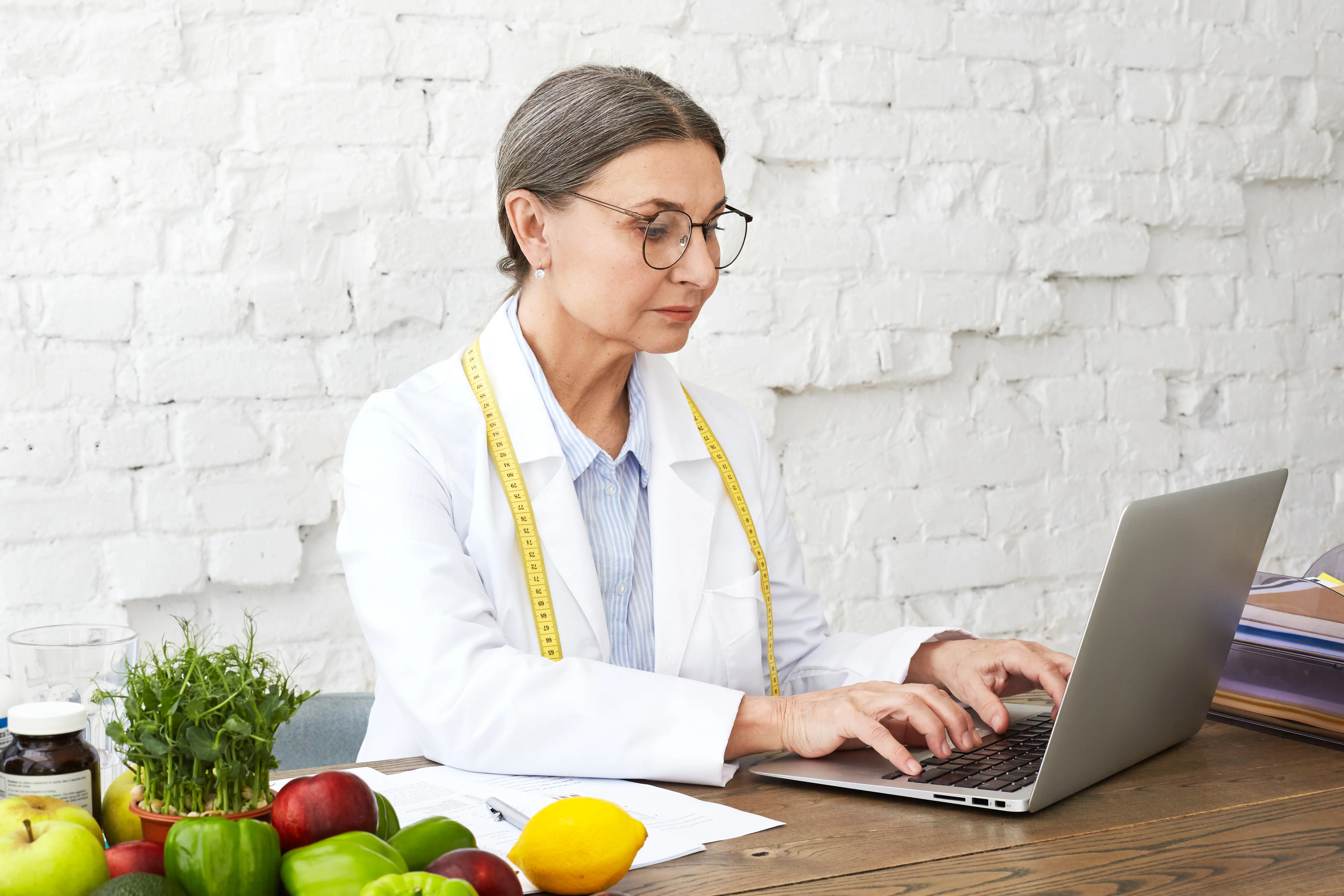 Nutrióloga comparando registros de dos consultas de seguimiento en el expediente de un paciente